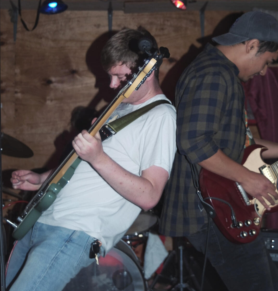 Rock band mates leaning during performance.